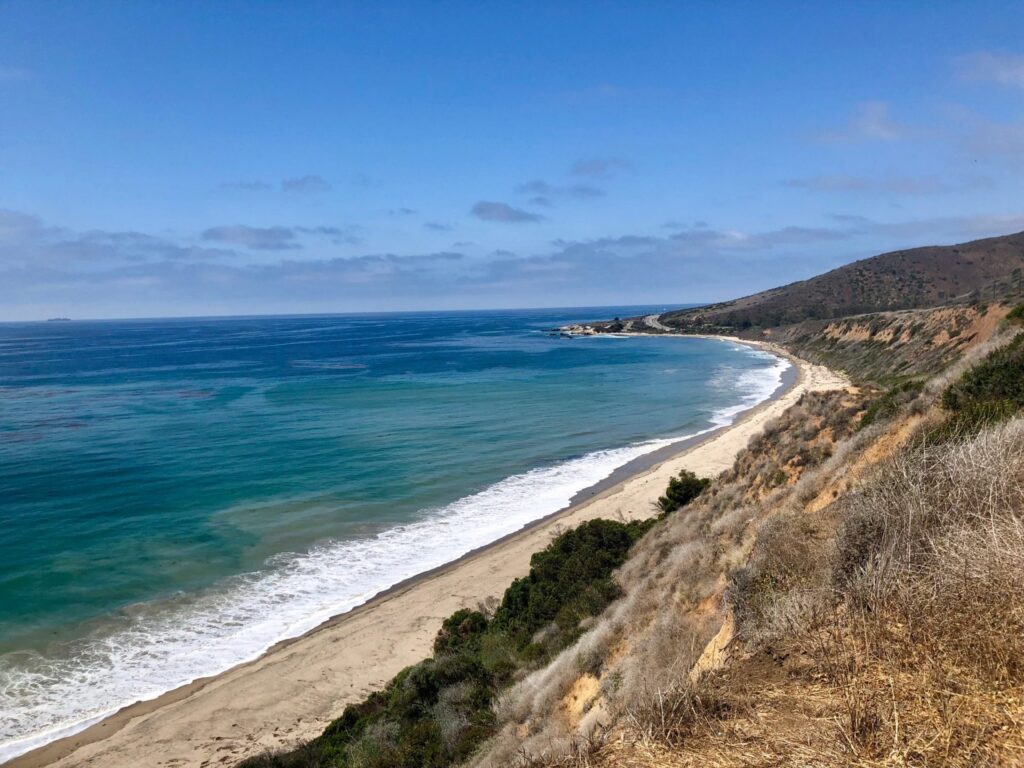 Panoramic ocean view and sandy shoreline at Nicholas Canyon Beach in Malibu, California.