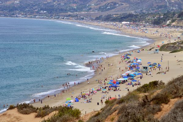 Wide sandy shoreline and blue ocean waves at Zuma Beach in Malibu, California.